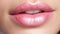 beautiful female lips with pink lipstick with macro photo viewed from front