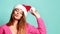 Beautiful female model wear xmas santa hat happy smiling kissing in pink blouse on blue mint