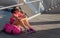 Beautiful female runner resting and eating an apple on a bridge.