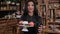 A beautiful female saleswoman holds a plate of cakes and coffee in her hands.