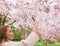 Beautiful female shooting blossom flowers with her mobile phone