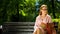 Beautiful female student sitting on bench with copybooks, resting after study