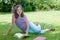 Beautiful female teenage reading a book on the grass