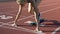 Beautiful female track runner leaves starting blocks in slow motion, competition