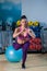 Beautiful female trainer shows exercises with a ball in the gym