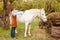 beautiful female vet inspects a white horse. Love, medicine, pet care, trust, happiness, health. back, withers. Illness