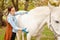 beautiful female vet inspects a white horse. Love, medicine, pet care, trust, happiness, health. back, withers. Illness