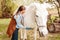 beautiful female vet inspects a white horse. Love, medicine, pet care, trust, happiness, health. The girl listens to the