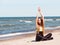 Beautiful female warming up on the beach. The girl athlete.