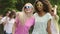 Beautiful females dancing to music and waving hands, enjoying summer party