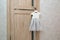 Beautiful festive baby dress hanging on door handle near grey wall. Preparing for the holiday. Waiting for birthday or