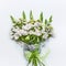 Beautiful festive flowers bouquet with bow and ribbon on white