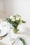 Beautiful festive table setting with elegant white flowers and cutlery, dinner table decoration