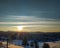 Beautiful field in nature covered in snow on a sunny blue sky winter cold cozy day and evergreen forest in holiday season