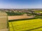 Beautiful field of yellow rapeseed from above. Green fields. Grape fields. A small German village. Beautiful blue sky.