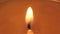 Beautiful fire of a candle in a dark room, a warm yellow candle