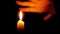 Beautiful fire of a candle in a dark room, a warm yellow candle quietly burning in the dark.
