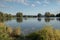 Beautiful fish pond in Badin, near Banska Bystrica, Slovakia. Trees mirror reflection in the water. Fishing place. Shining sun