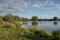 Beautiful fish pond near Badin, Banska Bystrica, Slovakia. Sky and trees mirror reflection in the water. Fishing place. Shining