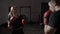 Beautiful fit female kickboxer training hard for the big match with her male box coach in gym sport studio in slow motion -