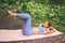 Beautiful fit woman in sportswear doing exercises on pink yoga mat. Muscular slim attractive female with flat belly in summer park