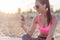 Beautiful fitness athlete woman wearing sunglasses resting listening music after work out exercising on summer evening