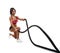 Beautiful fitness girl doing training using crossfit rope
