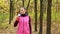 Beautiful fitness sport girl walking along the autumn park in sportswear with sports water bottle or isotonic drink in hand.