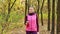 Beautiful fitness sport girl walking along the autumn park in sportswear with sports water bottle or isotonic drink in hand.