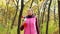 Beautiful fitness sport girl walking along the autumn park in sportswear with sports water bottle or isotonic drink in hand.