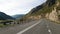 Beautiful flat empty asphalt road among the mountains. Accurate road markings. Traffic management in hard-to-reach places. Travel