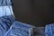 Beautiful flat lay close up of many jeans lay curvy on the dark wooden table