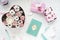 Beautiful flat lay on white table. Pastel colors, marshmallows,flowers,fountain pen, notepad,mascara,perfume.