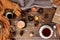Beautiful flat on an old wooden background, a cup of tea and sweets, coffee, candles, a gift in paper, cones, top view, the