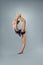 Beautiful flexible gymnast in sports outfit performs an element of rhythmic gymnastics