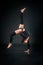 Beautiful flexible woman doing acrobatic elements against dark b