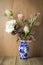 Beautiful flower in blue vase still life on wood background