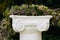 Beautiful flower garland on stone pedestal