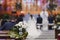 Beautiful flower wedding decoration in a church. Selective focus. Unrecognizable blurred Groom and bride on background. Marriage