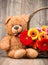 Beautiful flowers in the basket and a teddy bear