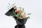 Beautiful flowers bouquet in black mate paper. Roses and pink carnation. White background.