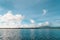 Beautiful, fluffy white clouds form white reflections in the rippled blue water of a bay along the Oregon coast