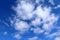 Beautiful fluffy white cumulus and cirrus clouds on a deep blue sky