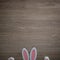 Beautiful fluffy white pink bunny paws and ears on a bright wooden background. Text space. Top view. Minimal style