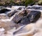 Beautiful foamy river flowing down on rocks