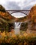 Beautiful foamy waterfall and a bridge in Letchworth State Parkin US in autumn on a gloomy day