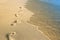 Beautiful footprints in the sand near the sea on nature background