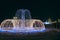 Beautiful fountains in city park. Colorful New Year garlands