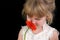 Beautiful Four Year Old Girl Smelling Flower Against Black Background