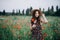 Beautiful free girl in a hat in a summer field of red poppies. Soft selective focus